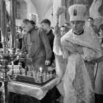 Czarno-biała fotografia przedstawia prawosławny rytuał religijny w cerkwi
