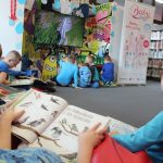 W pomieszczeniu Wypożyczalni dla Dzieci przedszkolaki czytają książki