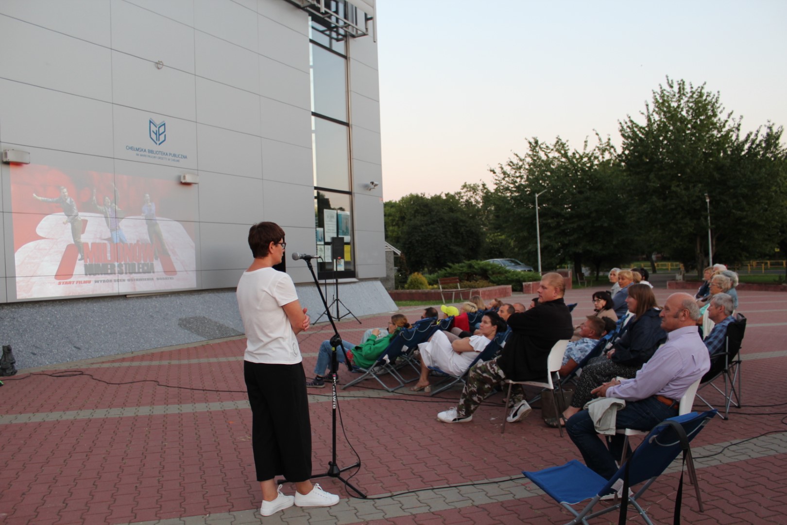 Plenerowa projekcja filmu "80 milionów" przed budynkiem Biblioteki