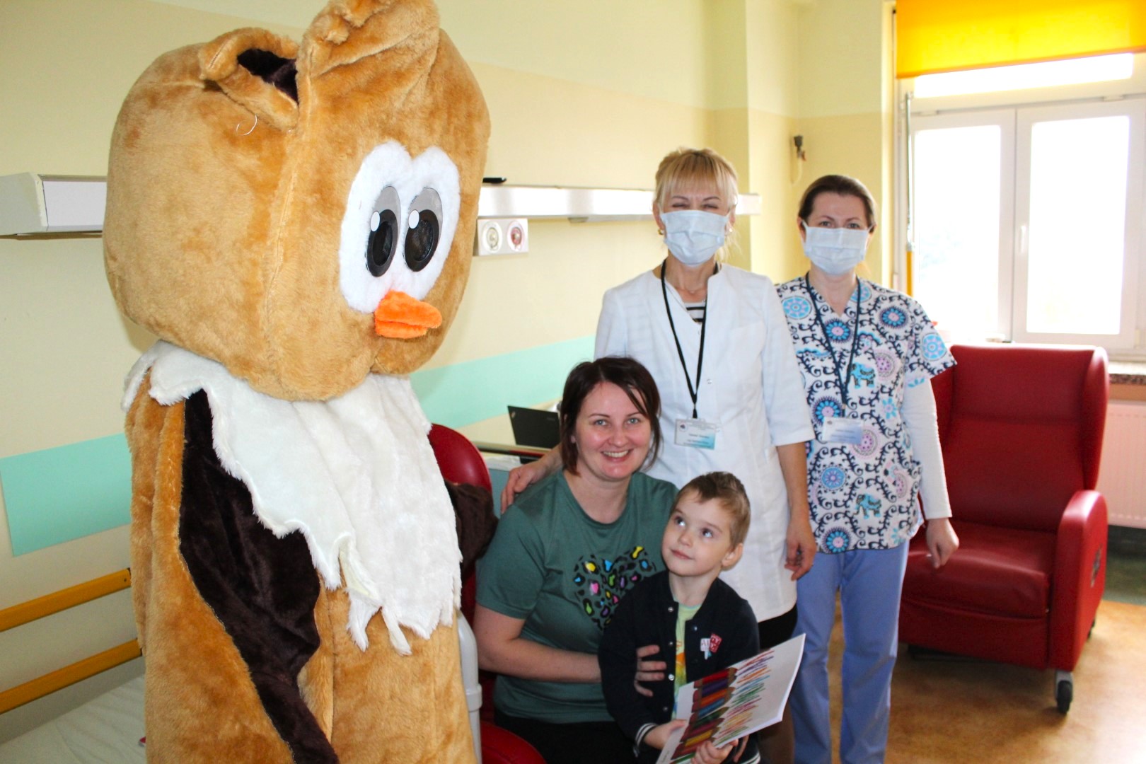 Na Oddziale dziecięcym szpitala pluszowa sowa pozuje do zdjęcia w dwiema paniami pielęgniarkami i pacjentami