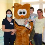 Na Oddziale dziecięcym szpitala pluszowa sowa pozuje do zdjęcia w dwiema paniami pielęgniarkami i pacjentkami