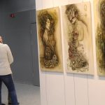 Finisaż wystawy grupy artystycznej Impuls Art w galerii Nova Biblioteki. Kobieta ogląda prezentowane na ścianach obrazy.