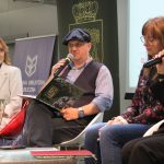 Autorzy książki - kobiet i mężczyzna oraz prowadząca spotkanie na scenie sali widowiskowej biblioteki