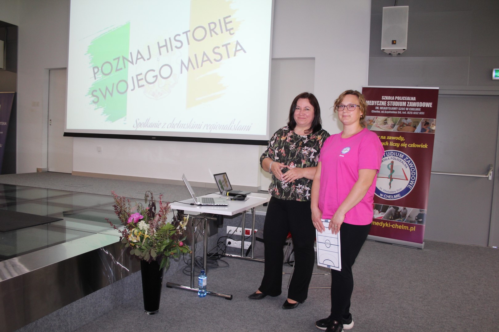 Dwie kobiety w sali widowiskowej biblioteki, w tle ekran
