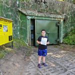 Chłopiec trzyma w ręku książkę na tle bunkra