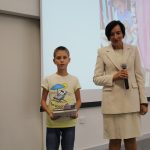 Kobieta z chłopcem pozuje do zdjęcia. Chłopiec trzyma książkę