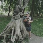 Chłopiec z książką stoi obok pomnika