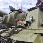 Chłopiec z książką siedzi na czołgu