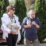 W słoneczny dzień mężczyzna przemawia do mikrofonu, obok stoi kobieta