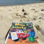 Książka na plaży, w tle morze