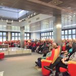 Młodzież - uczestnicy spotkania Pasja i kariera siedzą w sali widowiskowej biblioteki. Na scenie prowadząca wraz z zaproszonymi gościnami