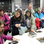 Grupa uczestników spotkania czeka w kolejce na podpis autorki książki