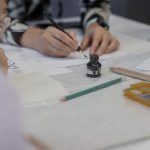 Na stole kałamarz i stalówka maczaną w atramencie