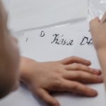 Dłonie dziecka, które pisze stalówką