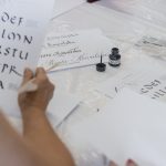 Na stole kartki oraz kałamarz
