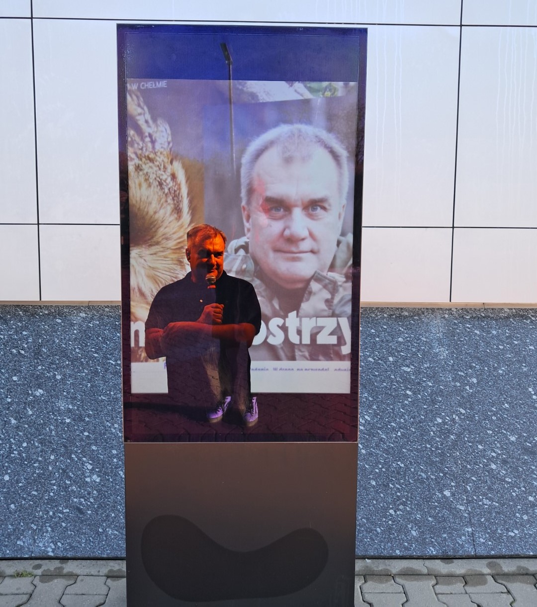 Zdjęcie mężczyzny - przyrodnika udostępnione na totemie przed budynkiem biblioteki