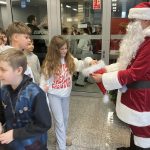 Mikołaj częstuje dzieci cukierkami