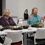 Kobiety siedzą przy świątecznie ubranym stole