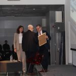 Wojciech Hetman wraz z prowadzącymi na scenie sali widowiskowej biblioteki