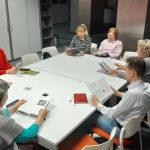 Grupa osób siedzi przy stoliku