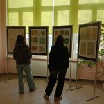 Wystawa na planszach stojących oglądana przez dwie dziewczyny.