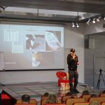 Rysownik - Hubert Ronek na scenie sali widowiskowej biblioteki