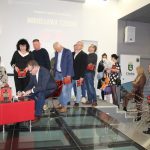 Uczestnicy spotkania z Mirosławem Czechem stoją w kolejce po autograf, autor podpisuje książki